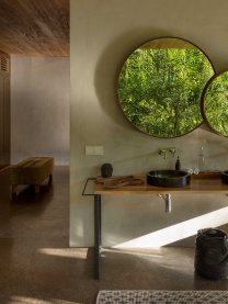 Well-positioned mirrors reflect the jungle greenery directly into the main living space.